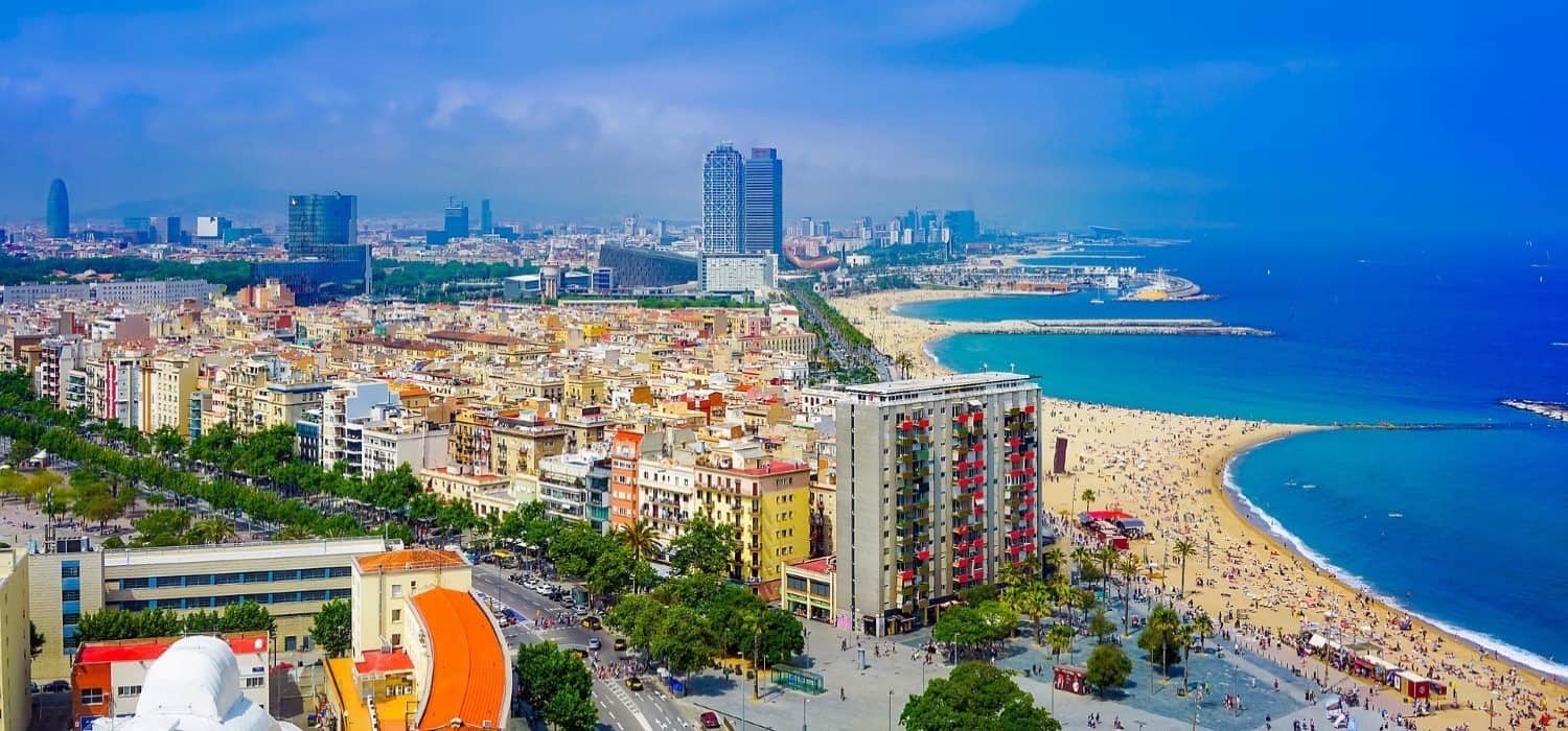 Barcelona from distance and beach. Travel with World Lifetime Journeys
