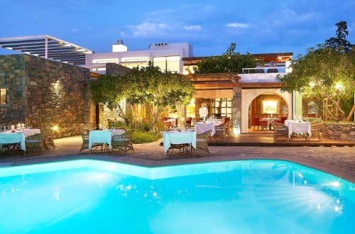 Pool side terrace at St. Nicolas Bay Resort Hotel & Spa in Agios Nikolaos, Crete. Travel with World Lifetime Journeys
