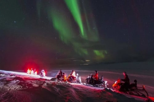 Snowmobiles under the Northern Lights. Travel with World Lifetime Journeys
