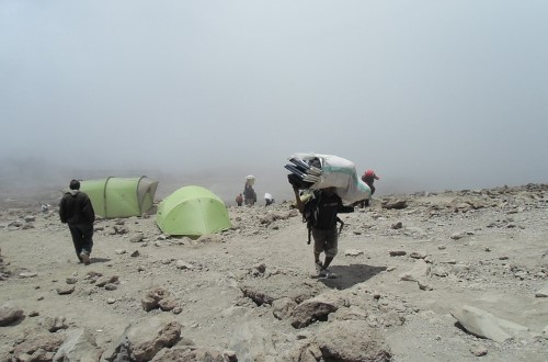 Porters carrying your luggage and goods on Kilimanjaro. Travel with World Lifetime Journeys
